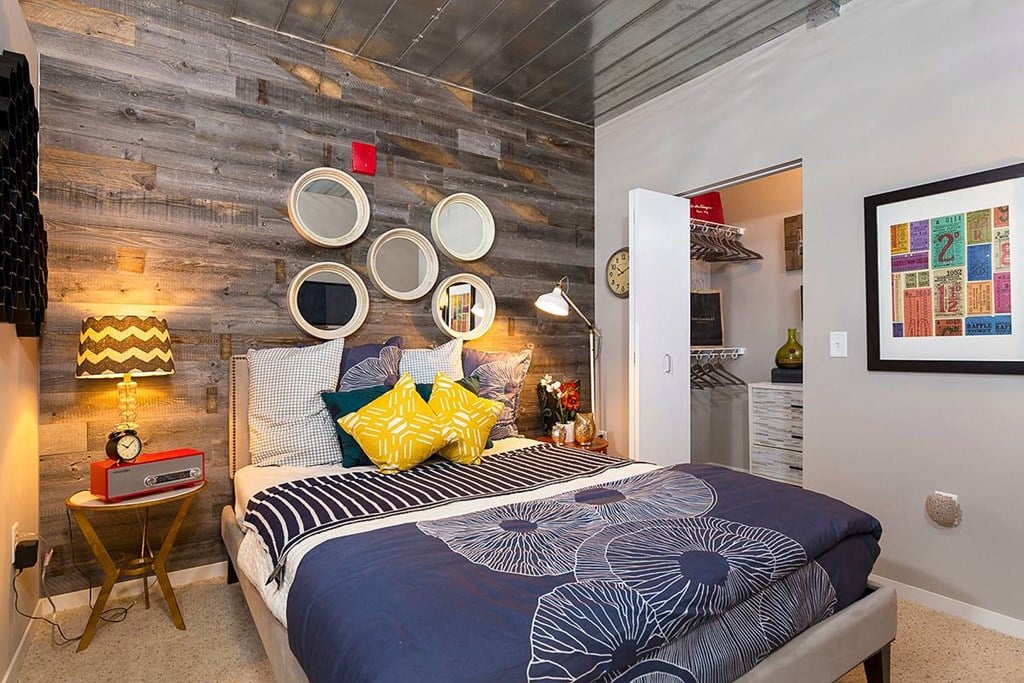 a bedroom with a bed and a wall with various plates on it at Ann Arbor City Club, Ann Arbor, 48104